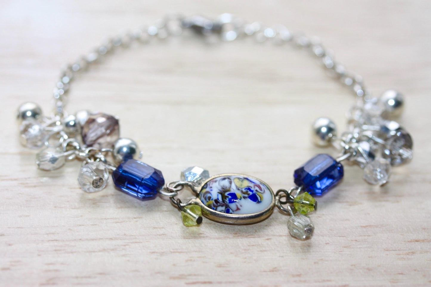 Handmade bracelet featuring a unique vintage art glass cabochon, royal blue faux crystals, yellow, pearl and clear crystal dangles - 7"