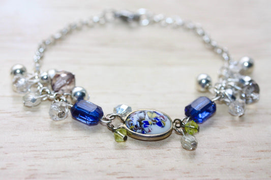 Handmade bracelet featuring a unique vintage art glass cabochon, royal blue faux crystals, yellow, pearl and clear crystal dangles - 7"