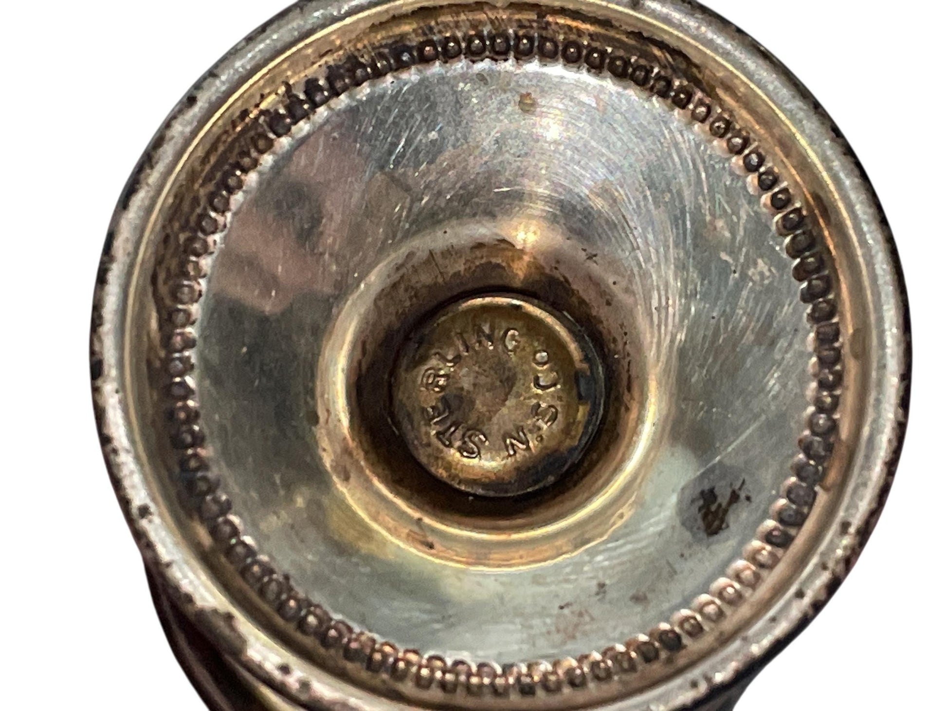 A close-up view of a metal container with a engraved label in the center.