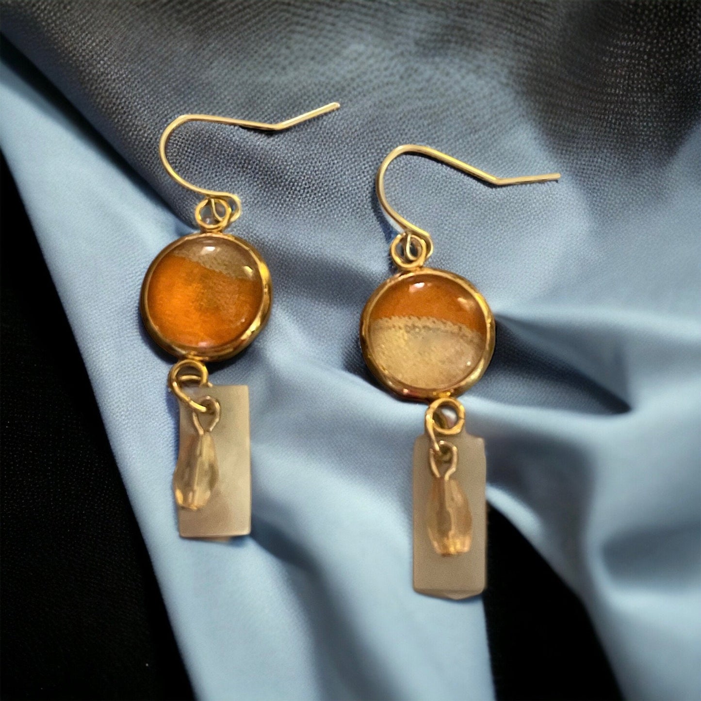 Orange and cream fabric inlaid glass cabochon earrings with rectangular mother of pearl and pale orange dangles