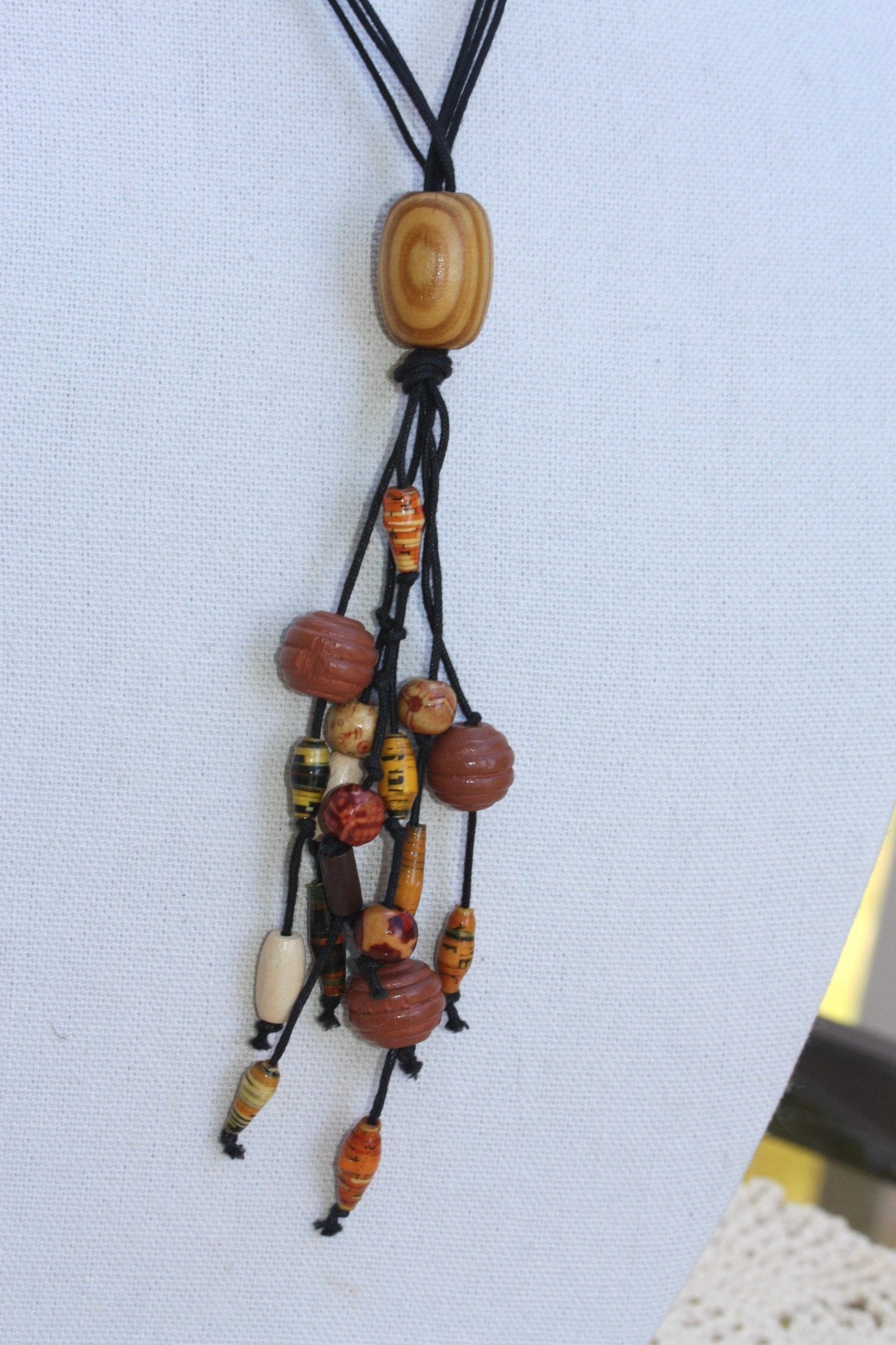 Long vintage wood, paper, glass mixed material vintage tassel necklace on black satin