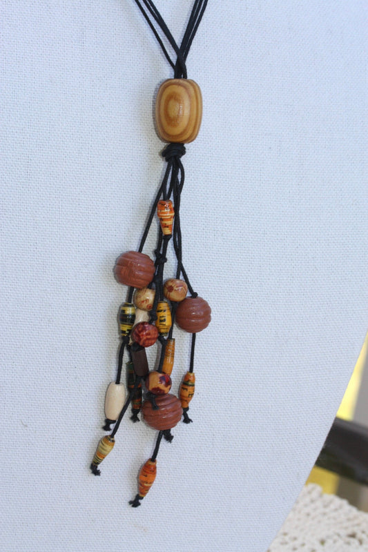 Long vintage wood, paper, glass mixed material vintage tassel necklace on black satin