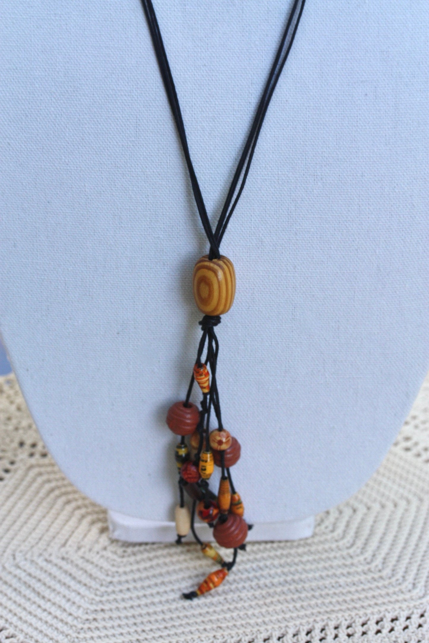 Long vintage wood, paper, glass mixed material vintage tassel necklace on black satin