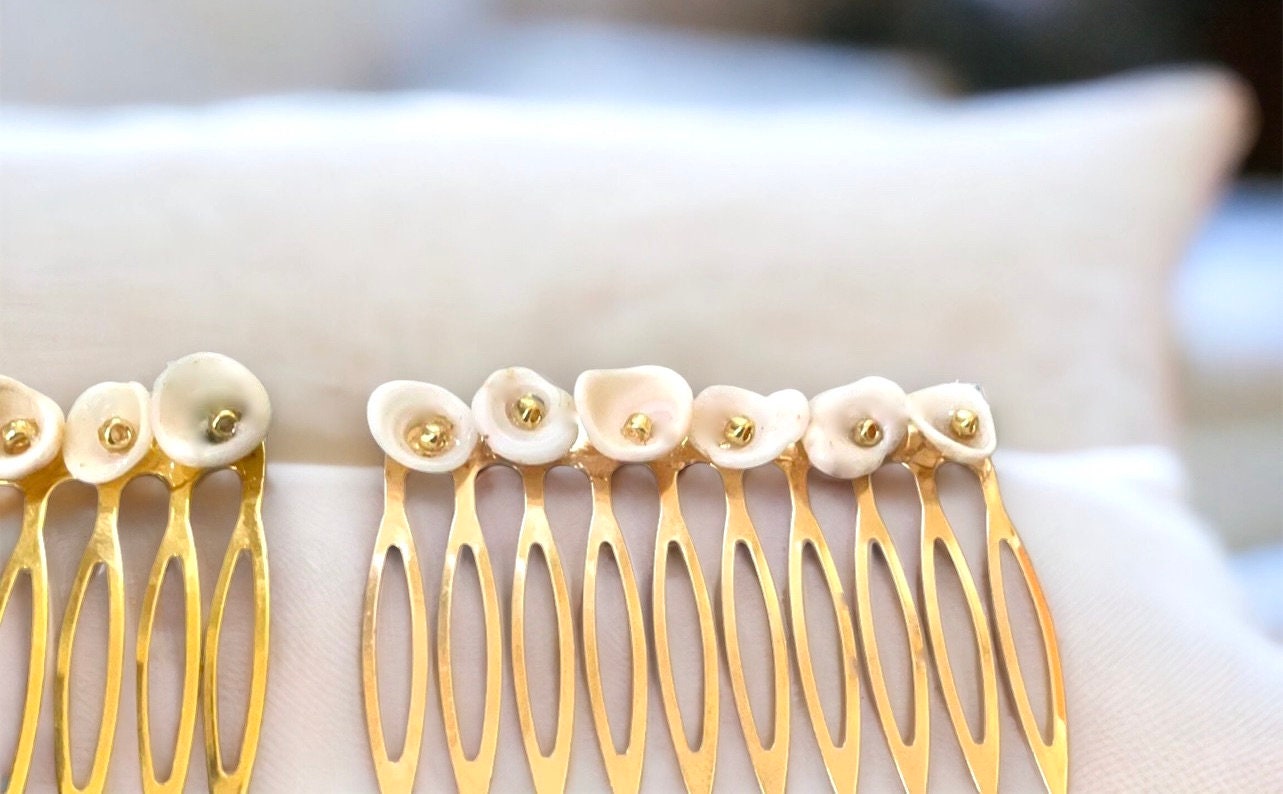 Pair of ivory white shell hair combs with goldtone centers
