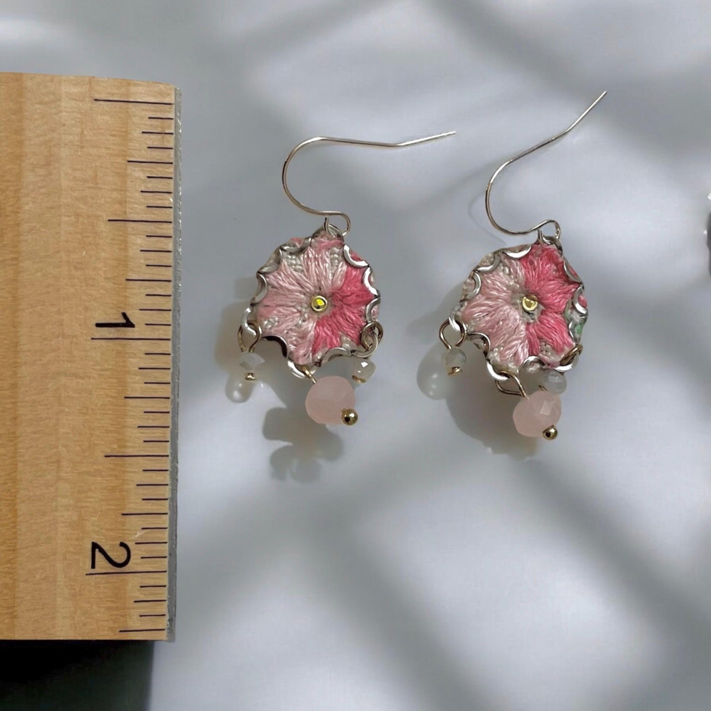 Handmade shades of pink mixed media earrings made with embroidery from a vintage linen table runner, combined with tiny dangles