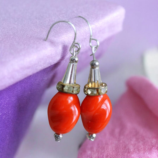 Unique dangle earrings featuring orange free form slightly twisted vintage glass, metal cone beads and rhinestone spacers