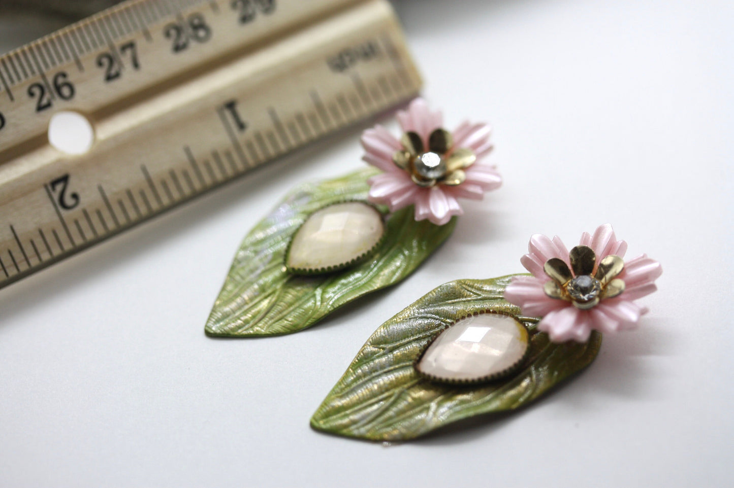 Hand painted leaf earrings with inlaid cabochan, vintage mixed material pink and metal flowers and capped off with rhinestone center