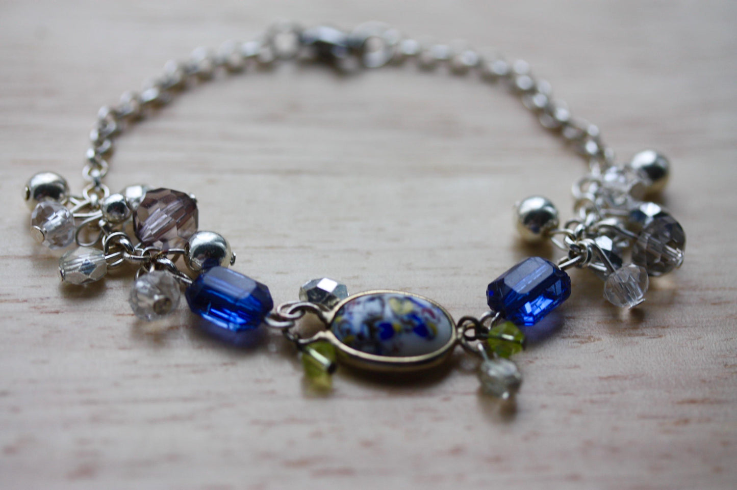 Handmade bracelet featuring a unique vintage art glass cabochon, royal blue faux crystals, yellow, pearl and clear crystal dangles - 7"