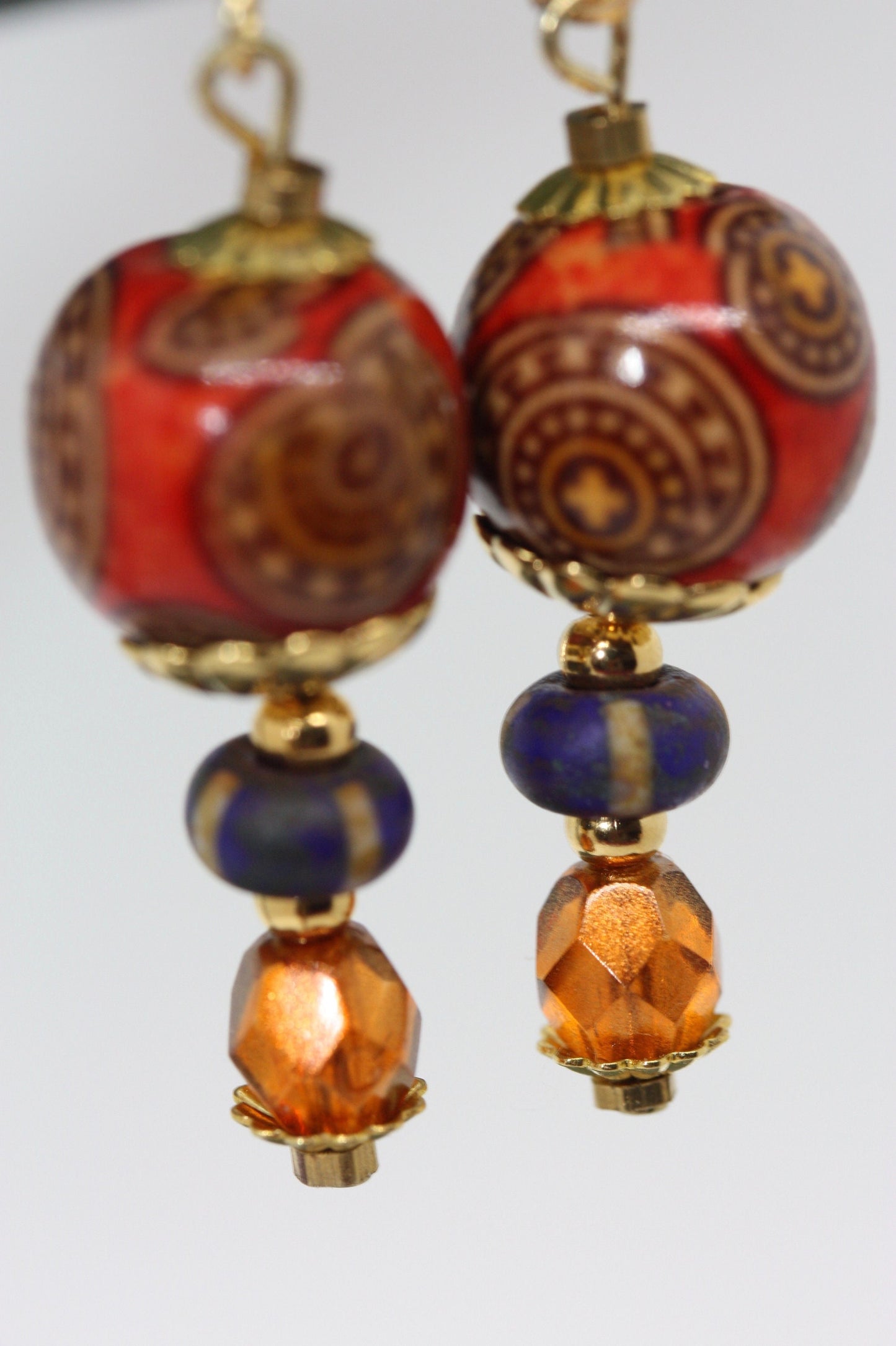 Burnt orange beaded earrings - paper covered beads, purple with cream stripes, orange fire polished crystals