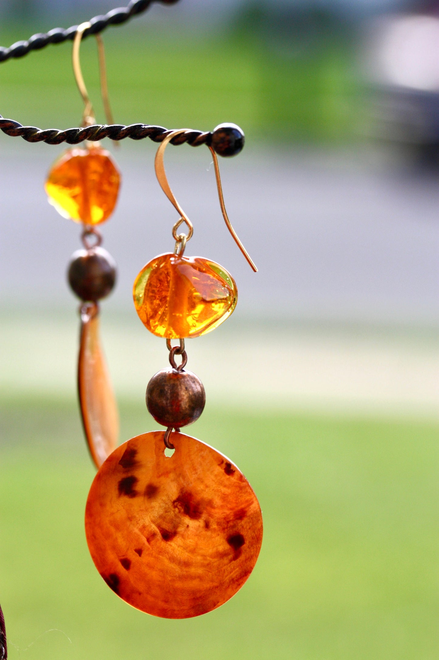 Handmade dangle earrings composed of upcycled orange blown glass, orange mother of pearl and copper beaded spacer beads