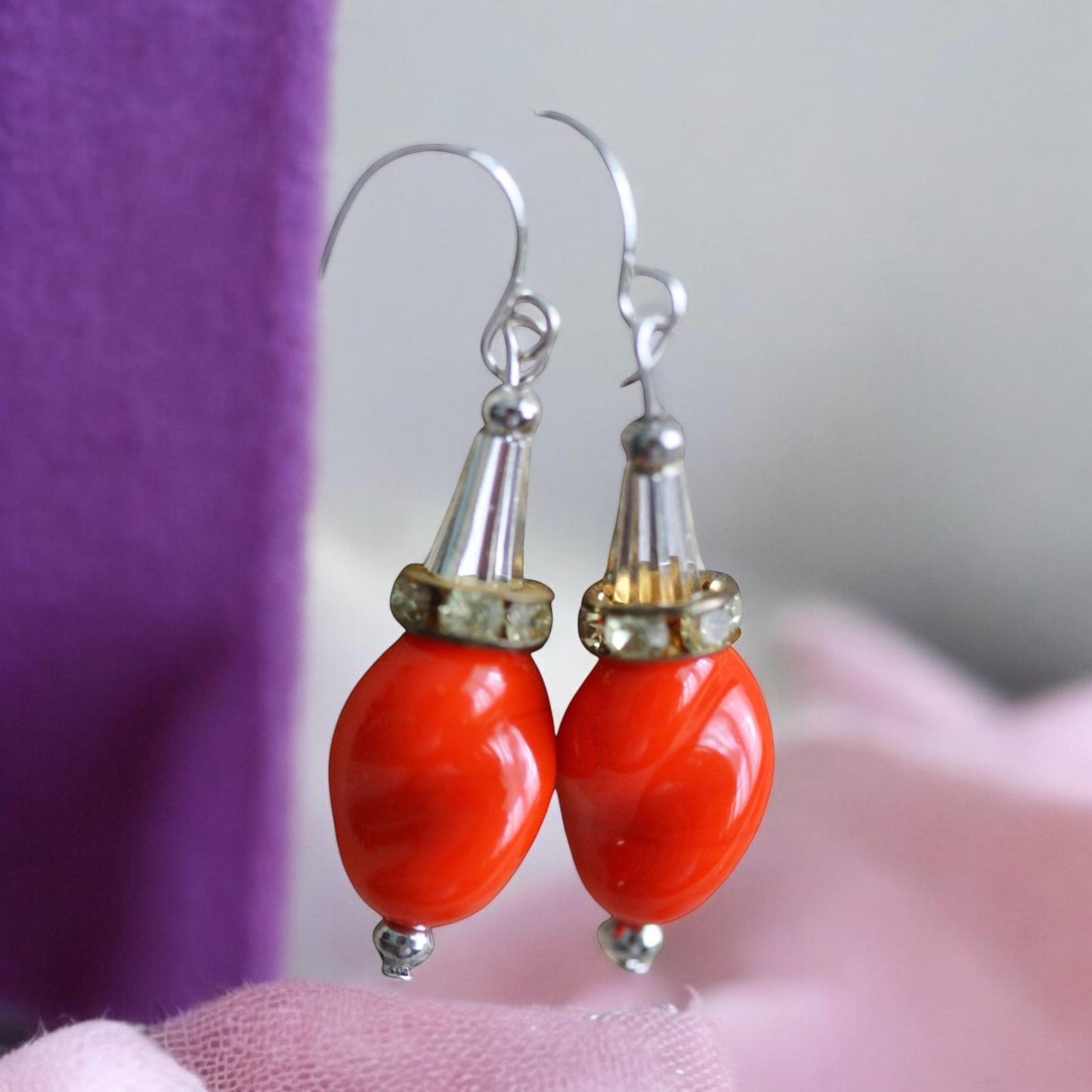 Unique dangle earrings featuring orange free form slightly twisted vintage glass, metal cone beads and rhinestone spacers