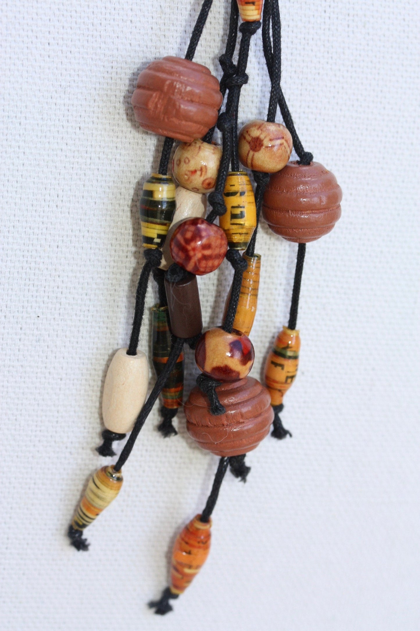 Long vintage wood, paper, glass mixed material vintage tassel necklace on black satin
