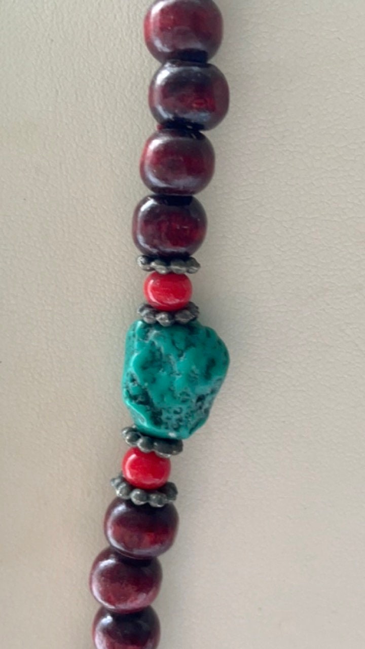 Long turquoise and wood vintage beaded necklace on red satin