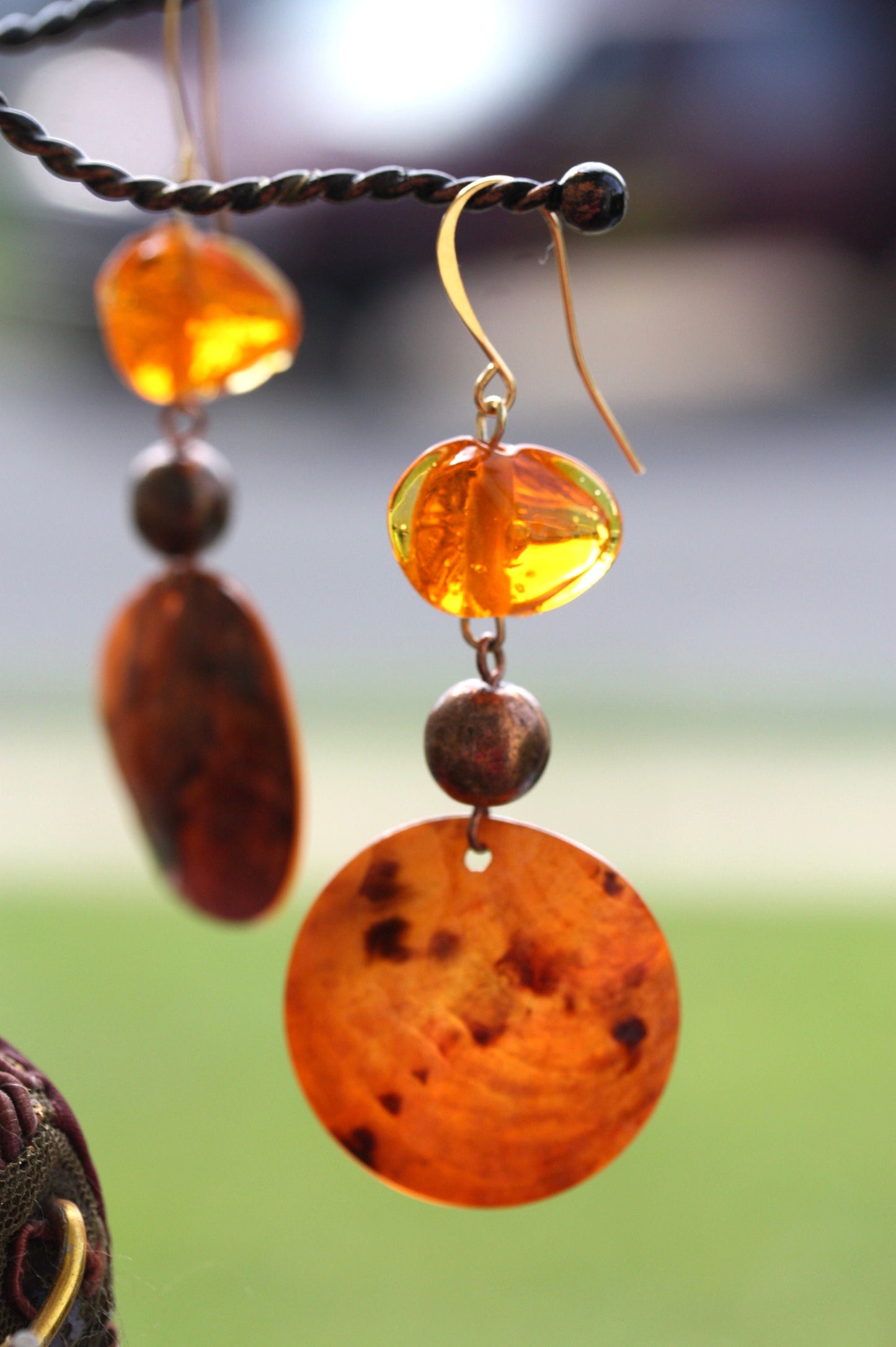 Handmade dangle earrings composed of upcycled orange blown glass, orange mother of pearl and copper beaded spacer beads