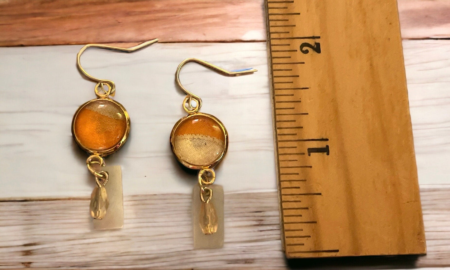Orange and cream fabric inlaid glass cabochon earrings with rectangular mother of pearl and pale orange dangles