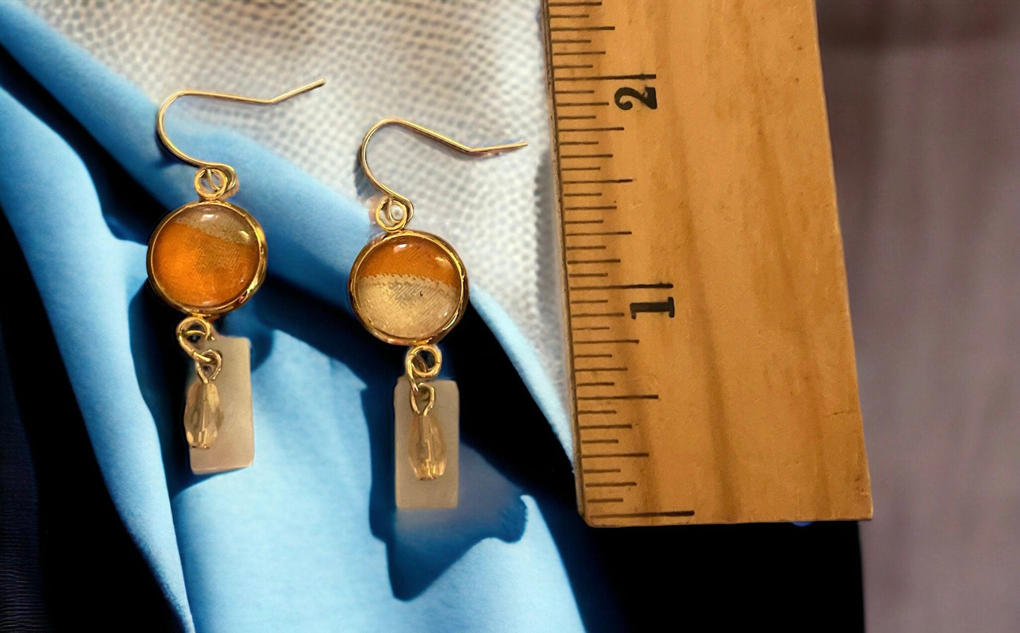 Orange and cream fabric inlaid glass cabochon earrings with rectangular mother of pearl and pale orange dangles