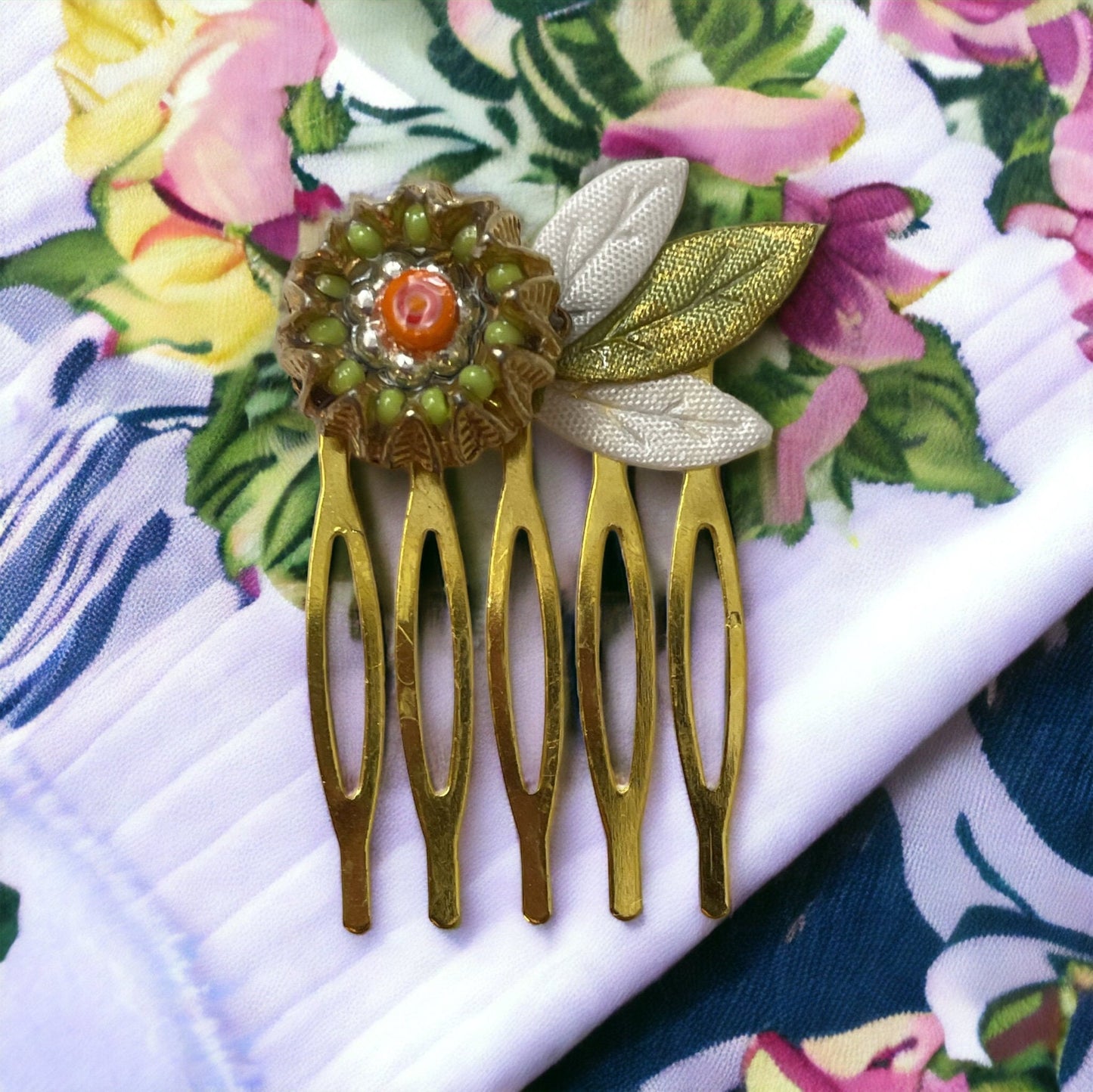 Small 1" hair comb featuring beaded mixed medium upcycled metal floral crown trimmed with satin green and white leaves.