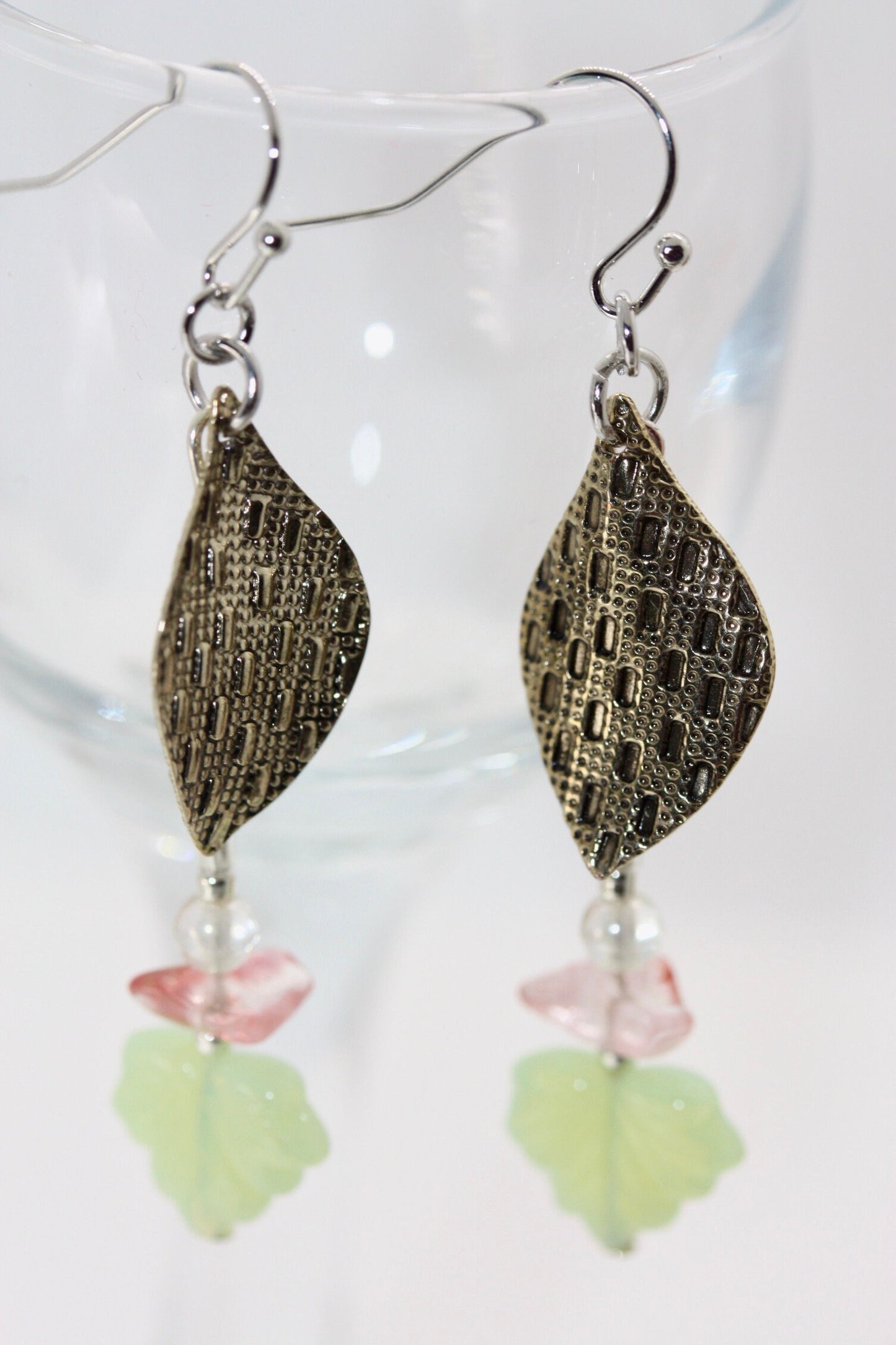 Handmade dangle earrings made of vintage textured metal leaves, pink gemstone chips and light green opaline glass ginko flower leaves