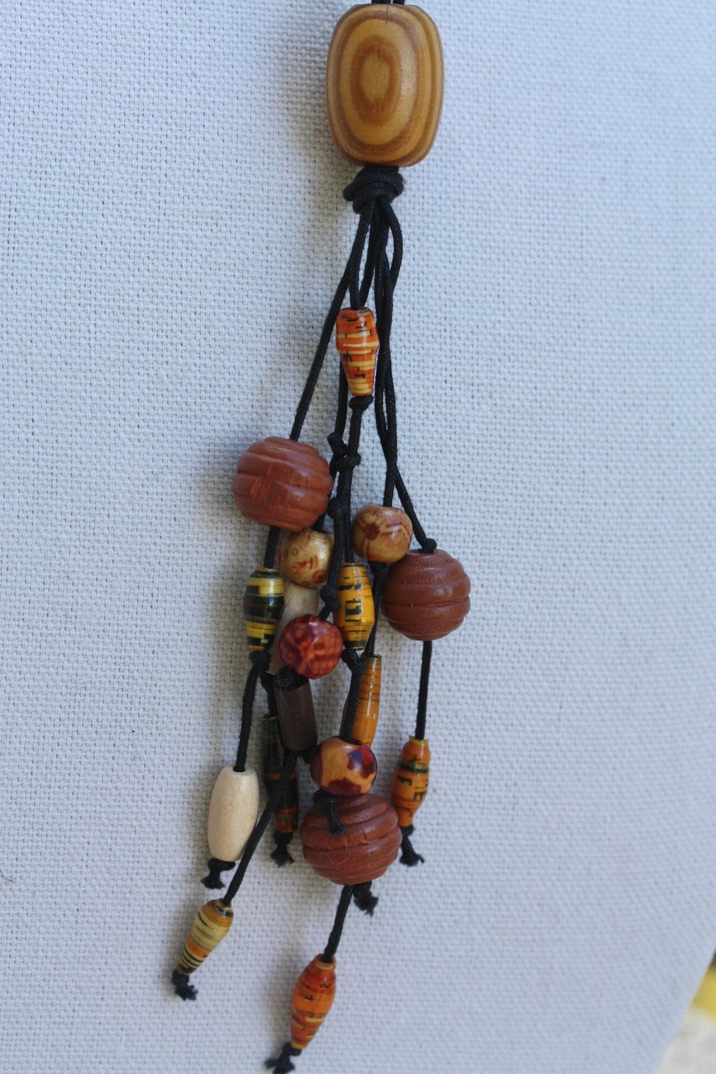 Long vintage wood, paper, glass mixed material vintage tassel necklace on black satin