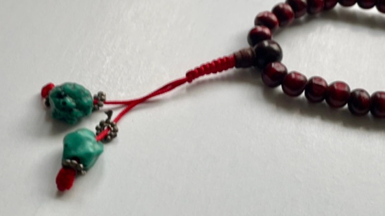 Long turquoise and wood vintage beaded necklace on red satin