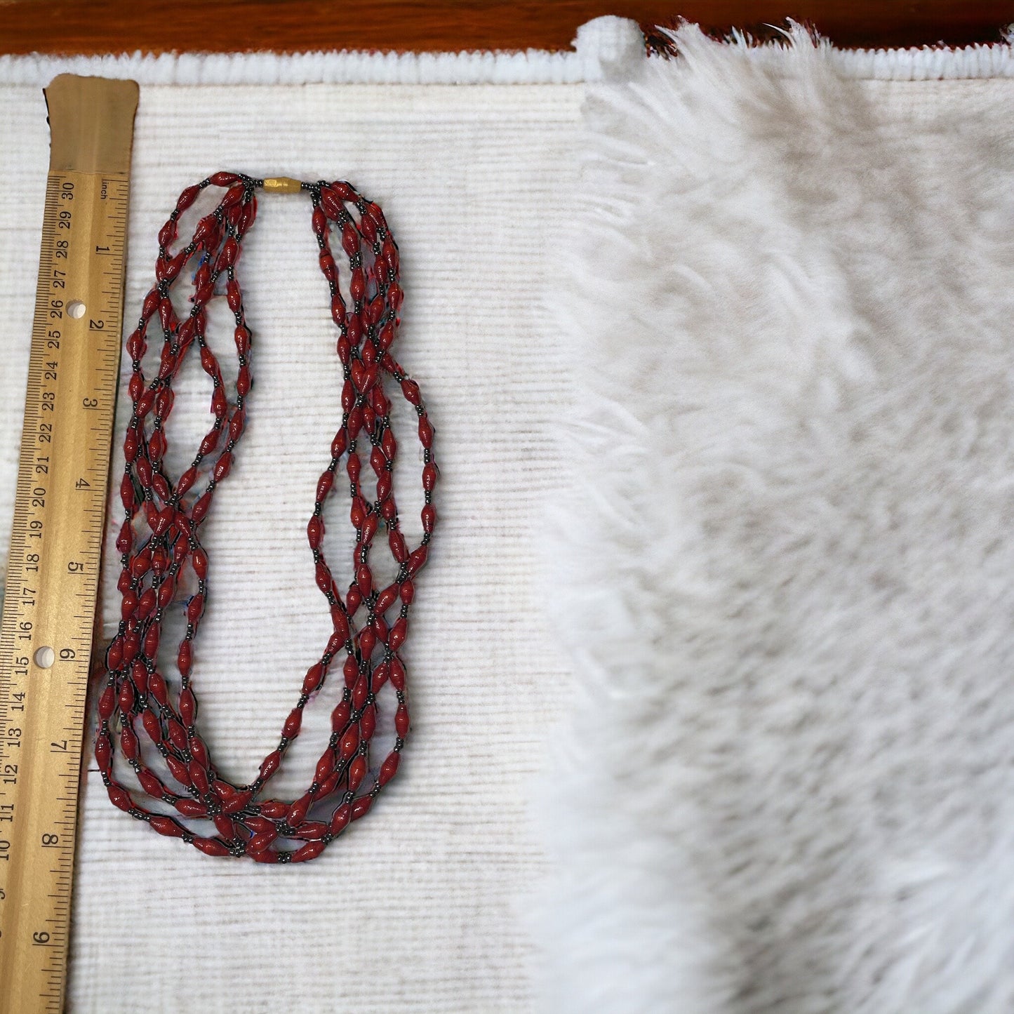 Three-strand necklace made of dozens of itsy bitsy extra tiny little rolled and sealed red paper beads