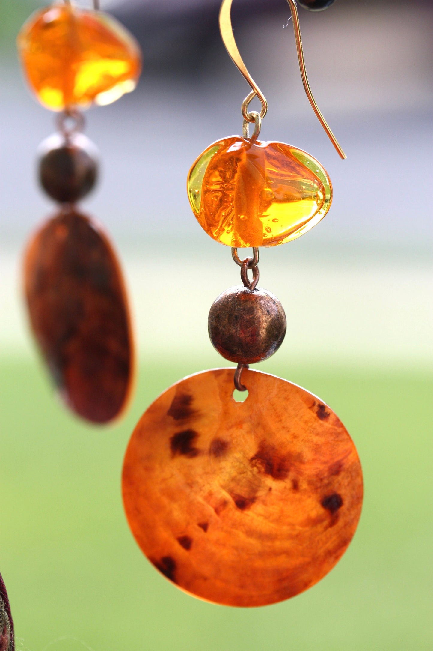 Handmade dangle earrings composed of upcycled orange blown glass, orange mother of pearl and copper beaded spacer beads