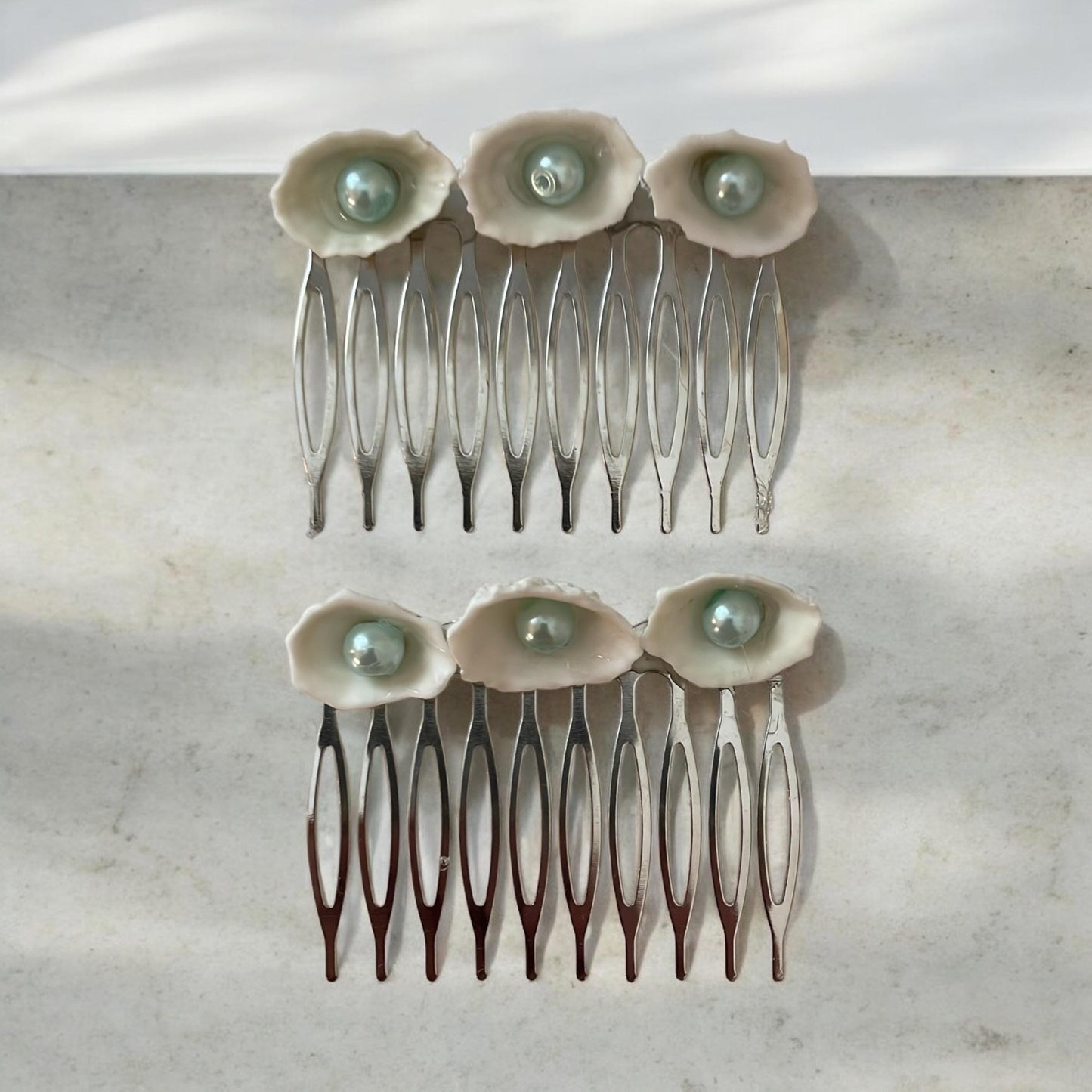 Pair of Hair combs made of white shells with light blue pearl centers
