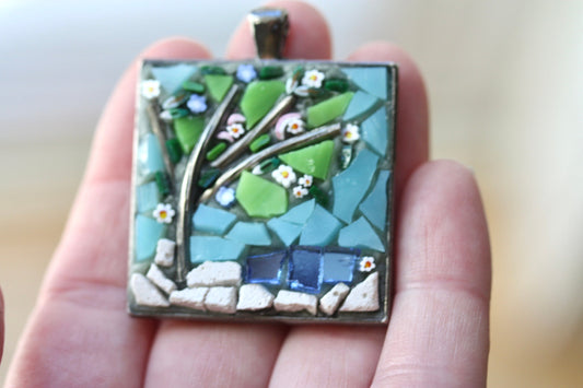 My handmade mosaic necklace - "Tree over pond" - ceramic and glass with blue mirrored "pond" and hand cut millefiori flowers