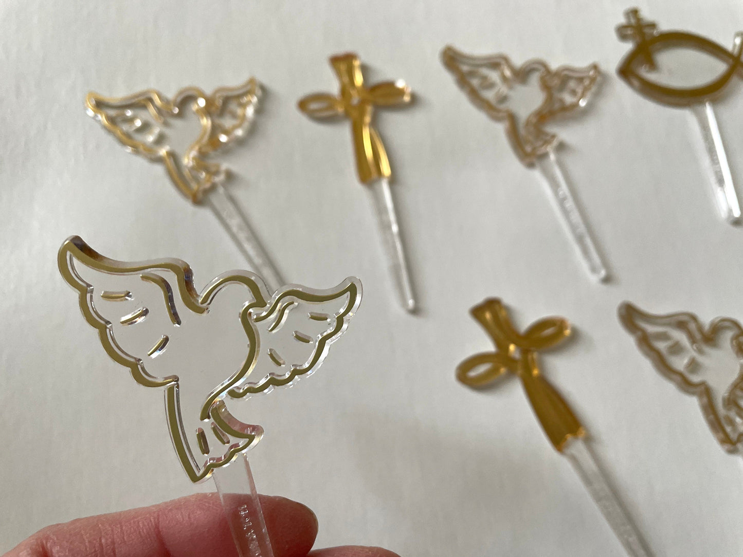 Mix of clear and gold plastic cake toppers - cross, fish and dove