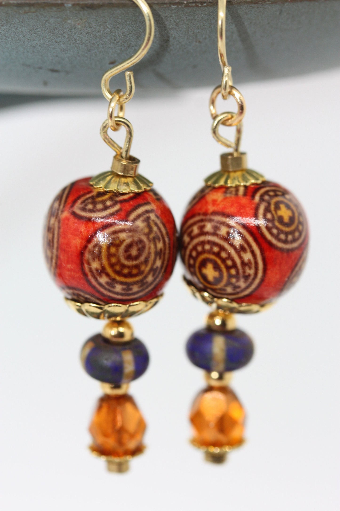 Burnt orange beaded earrings - paper covered beads, purple with cream stripes, orange fire polished crystals