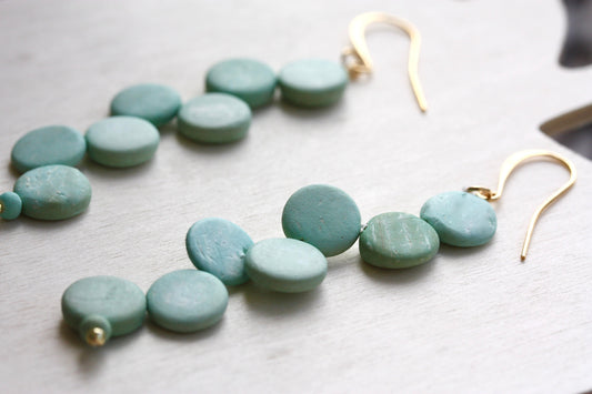 Handsewn aqua tinted wooden disk Scandinavian-inspired earrings - with sloped goldstone ear wires