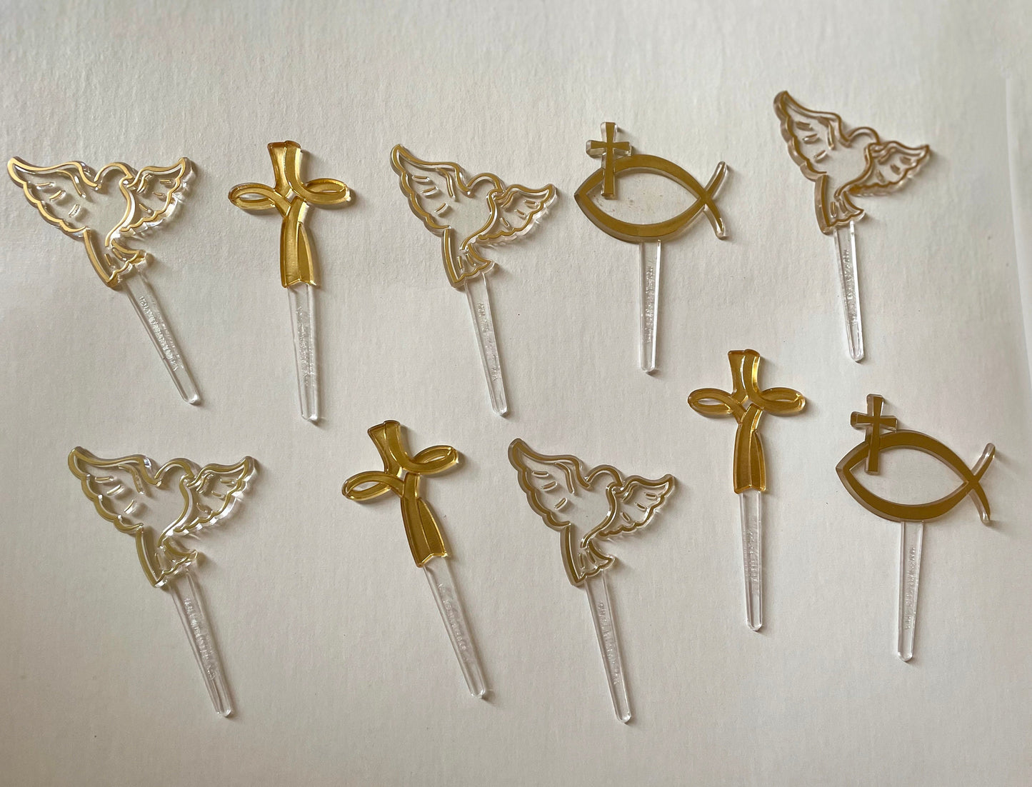 Mix of clear and gold plastic cake toppers - cross, fish and dove