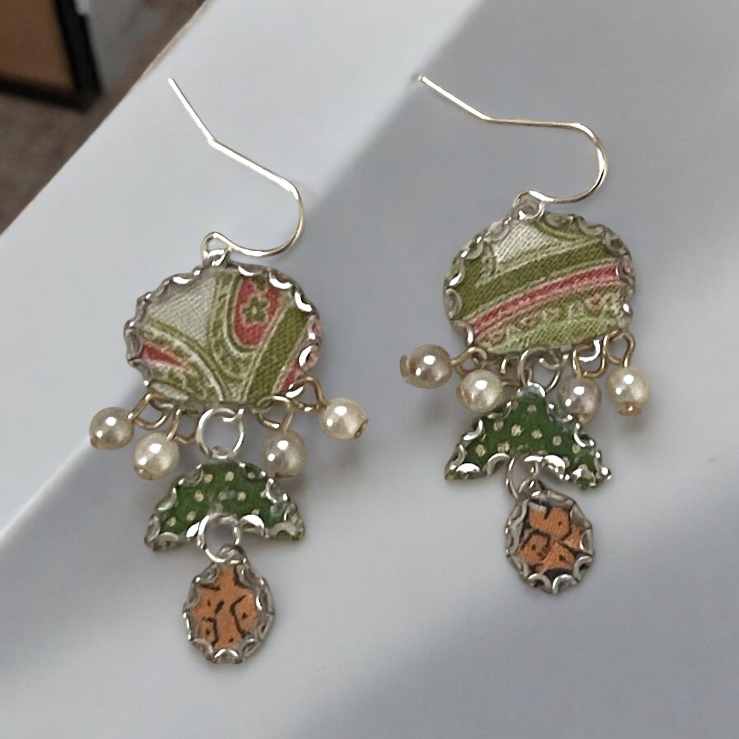 Handmade earrings featuring green and white polka dot fabric with peach and cream paisley and dangling faux pearls. Sterling ear wires.
